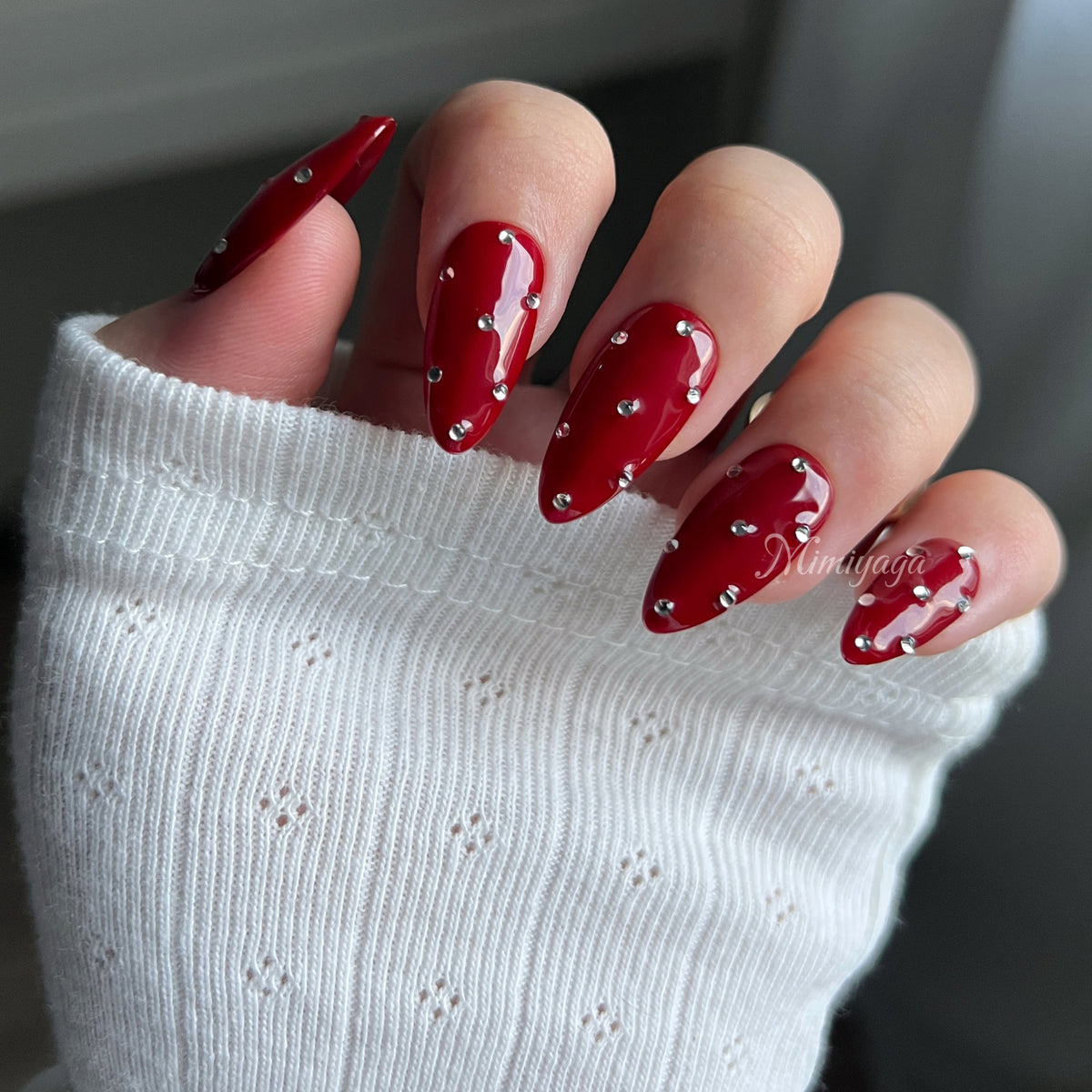 Ruby Studs handmade red press on nails with scattered silver crystals worn on hands