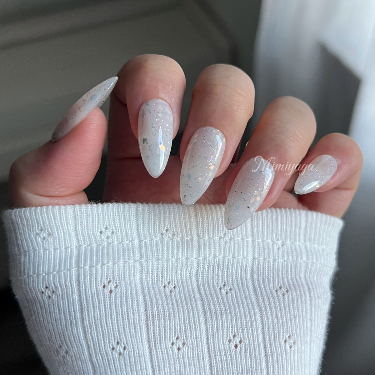Close-up of Snow Quartz handmade press on nails showing the translucent milky finish and scattered reflective flecks