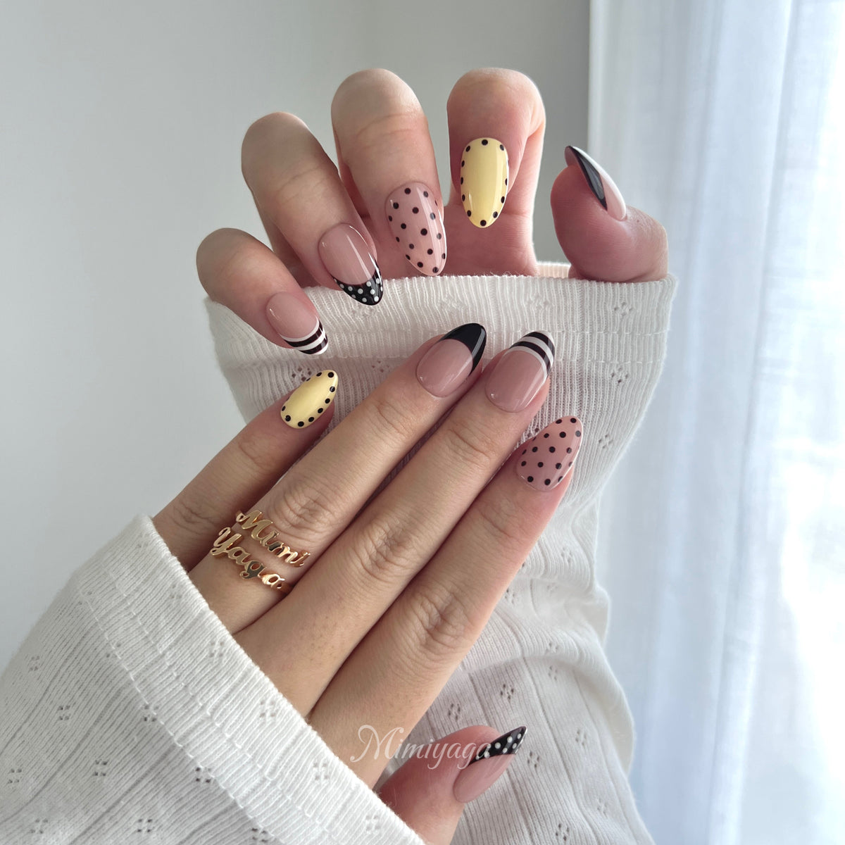 Close-up of Sunday Best handmade press on nails showing hand-painted French tips, polka dots and stripe details
